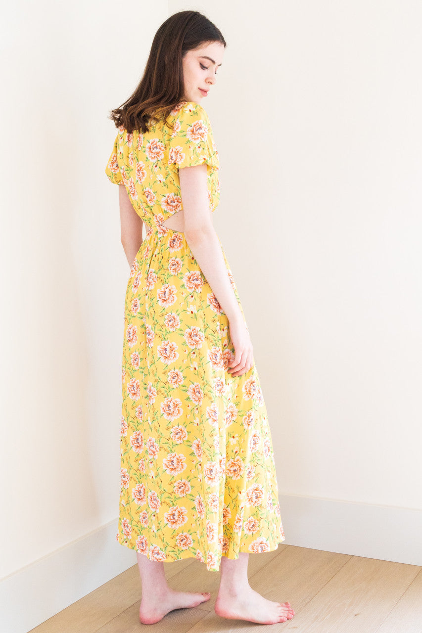 This stunning maxi dress features split sides for added movement and a touch of edge. It comes in a versatile black colour and a bold yellow floral print, perfect for making a statement at any summer occasion. Made from high-quality fabric, this dress exudes sophistication and is sure to elevate your summer wardrobe.