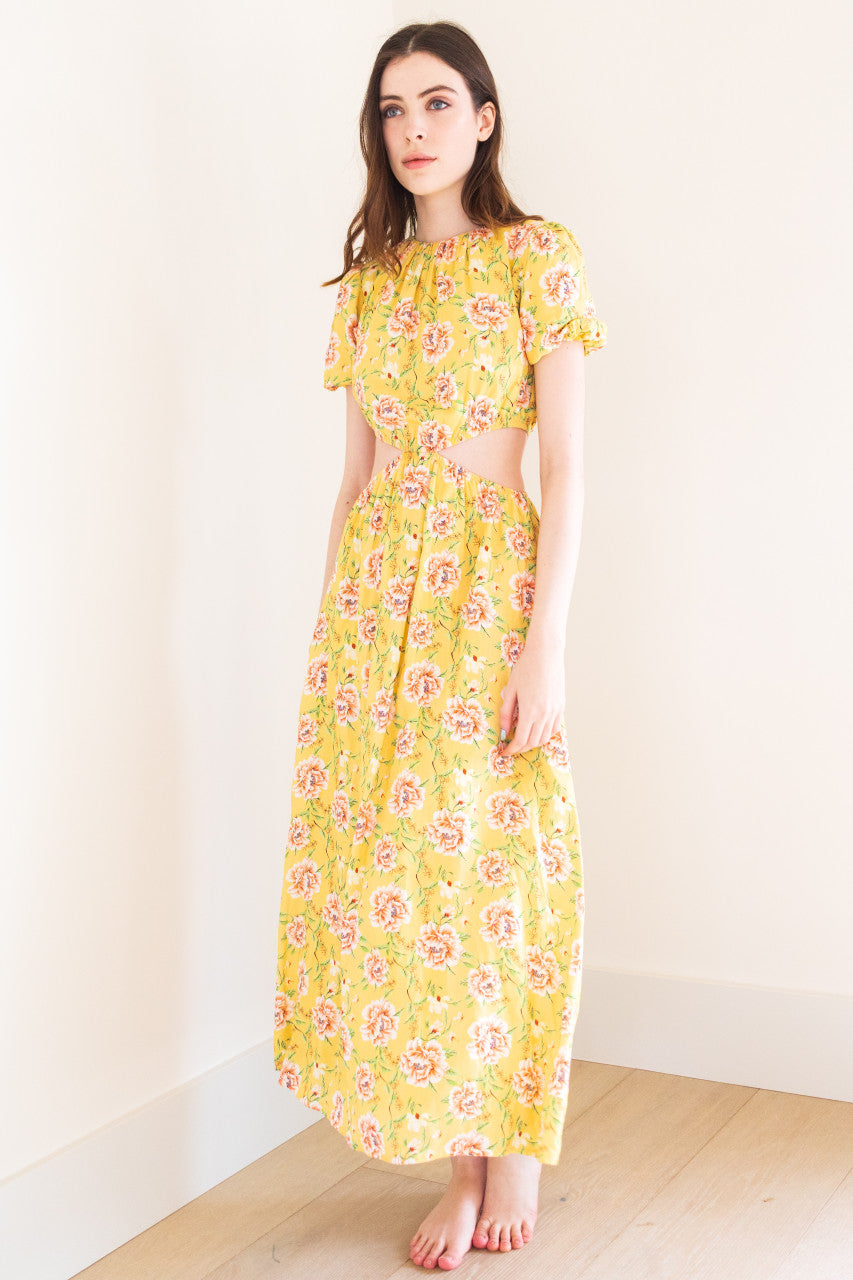 This stunning maxi dress features split sides for added movement and a touch of edge. It comes in a versatile black colour and a bold yellow floral print, perfect for making a statement at any summer occasion. Made from high-quality fabric, this dress exudes sophistication and is sure to elevate your summer wardrobe.