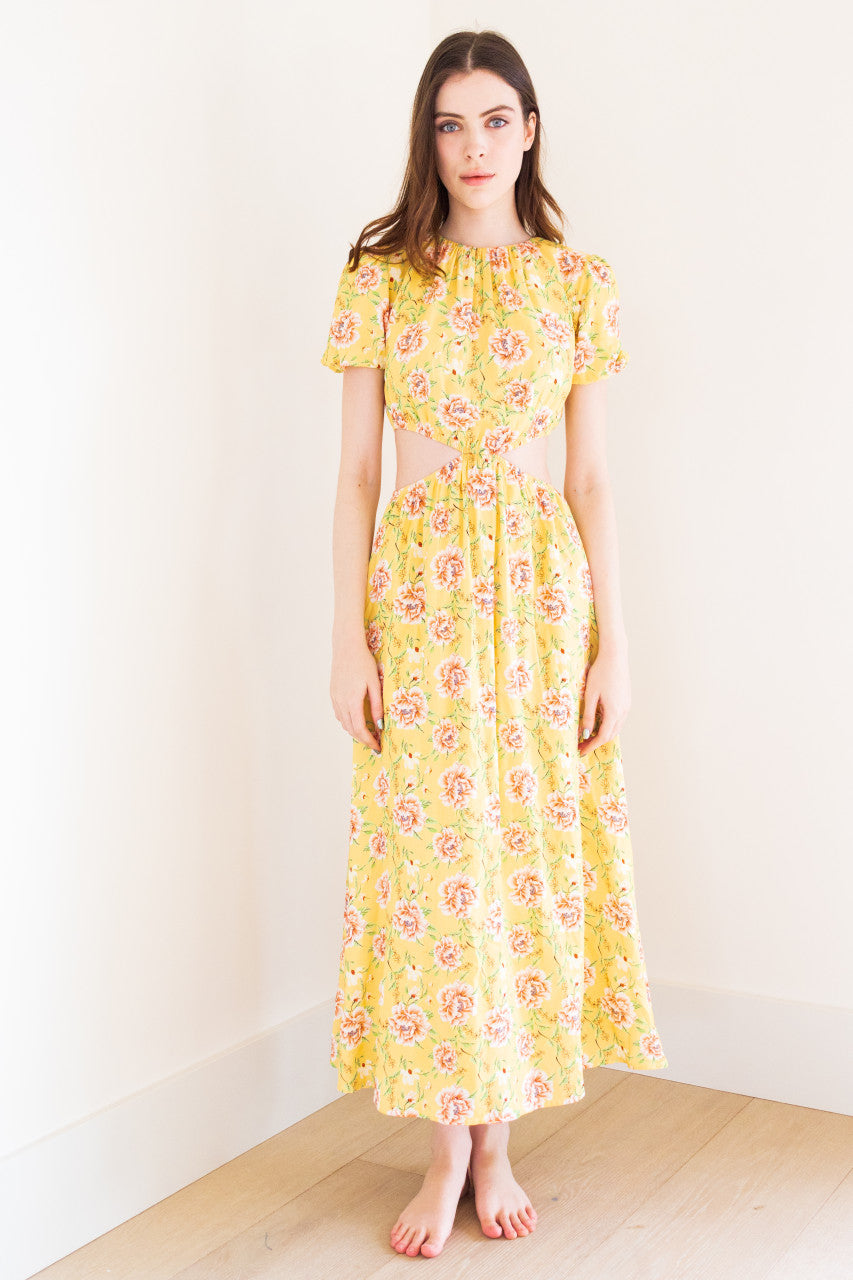 This stunning maxi dress features split sides for added movement and a touch of edge. It comes in a versatile black colour and a bold yellow floral print, perfect for making a statement at any summer occasion. Made from high-quality fabric, this dress exudes sophistication and is sure to elevate your summer wardrobe.
