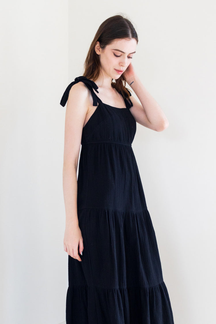 This tie shoulder poplin dress is crafted from a lightweight textured fabric for ultimate comfort. Available in both vivid pink and classic black, it's the perfect choice for casual get-togethers. The tie shoulder detail adds a playful touch to the effortlessly chic silhouette, making it a versatile addition to your summer wardrobe.