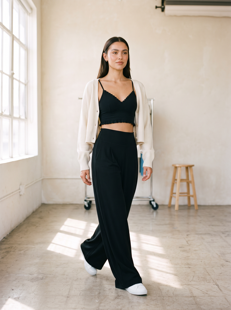 Model walking in FORM Kansas active wide leg pant in black with high waistband and pleats