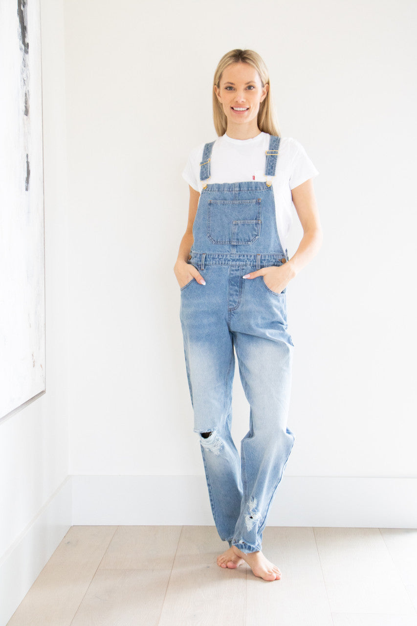 Your classic straight leg overall in a comfortably distressed blue. This full denim style features gold buckle accents, chest and side pockets and a tapered, straight leg finish. Pair with your favourite basic short or long sleeve tee and fall boot to complete this seasonal outfit.

