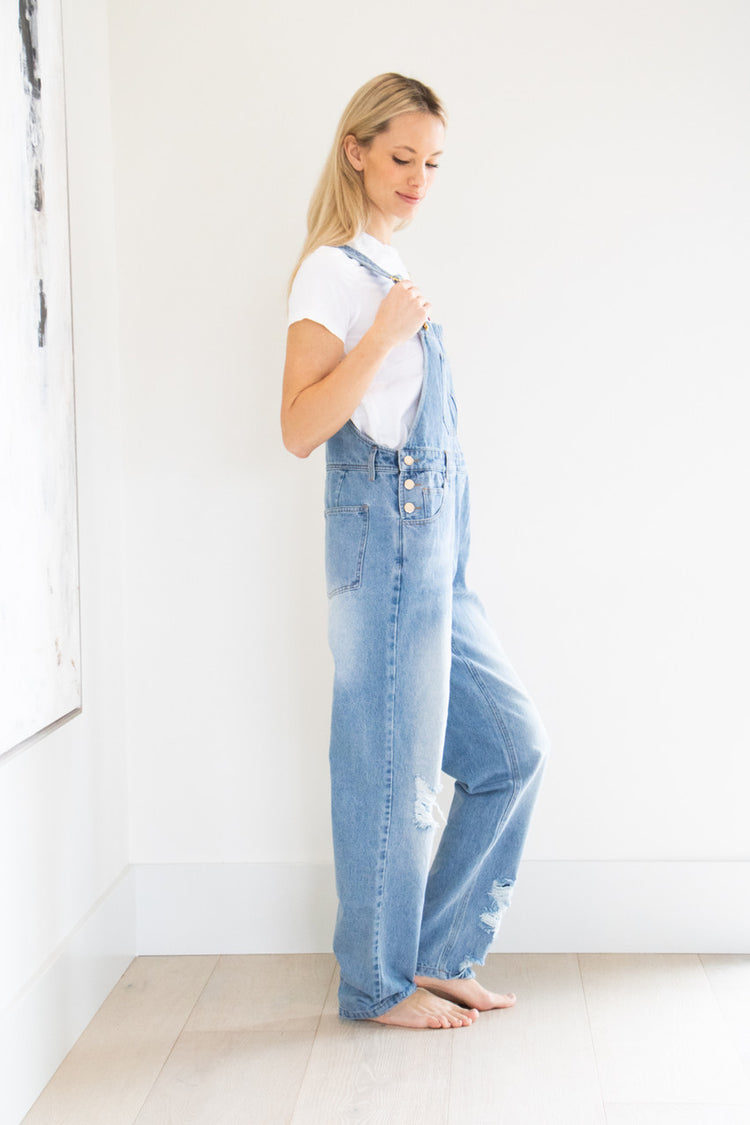 Your classic straight leg overall in a comfortably distressed blue. This full denim style features gold buckle accents, chest and side pockets and a tapered, straight leg finish. Pair with your favourite basic short or long sleeve tee and fall boot to complete this seasonal outfit.

