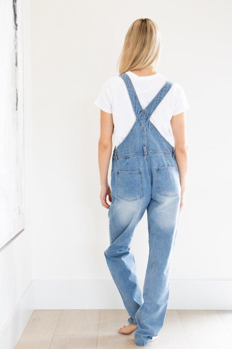 Your classic straight leg overall in a comfortably distressed blue. This full denim style features gold buckle accents, chest and side pockets and a tapered, straight leg finish. Pair with your favourite basic short or long sleeve tee and fall boot to complete this seasonal outfit.

