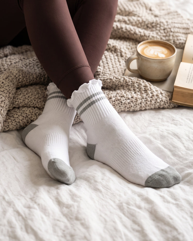 Stripe Ruffle Top Socks in Grey lounging in bed – PRIV
